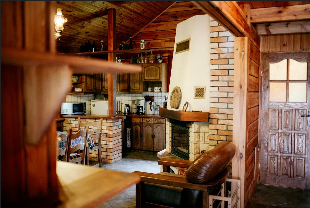 Salon, jadalnia i kominek w drewnianym domku